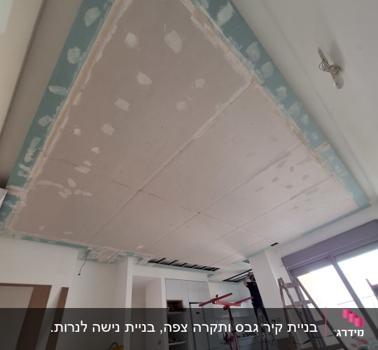 עבודת גבס בתקרה עם סולם וכלי עבודה